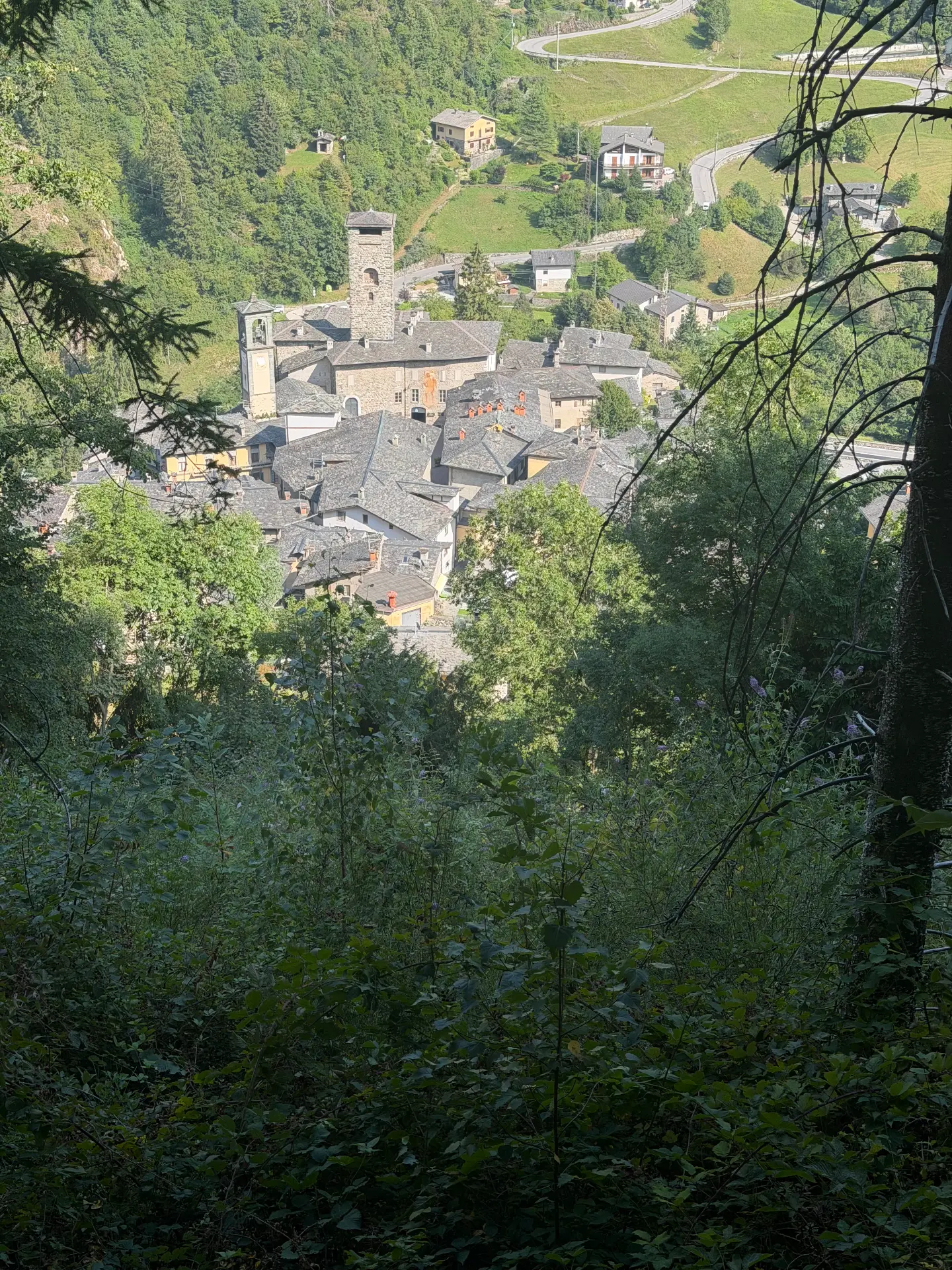 Stenen daken en bergen boven Gromo